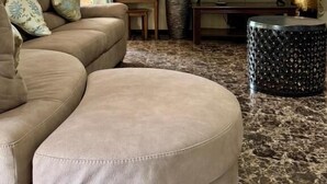 A living room with a sofa, ottoman, television, and a decorative vase. - Annavilla7 Lilongwe Hotel (Lilongwe)