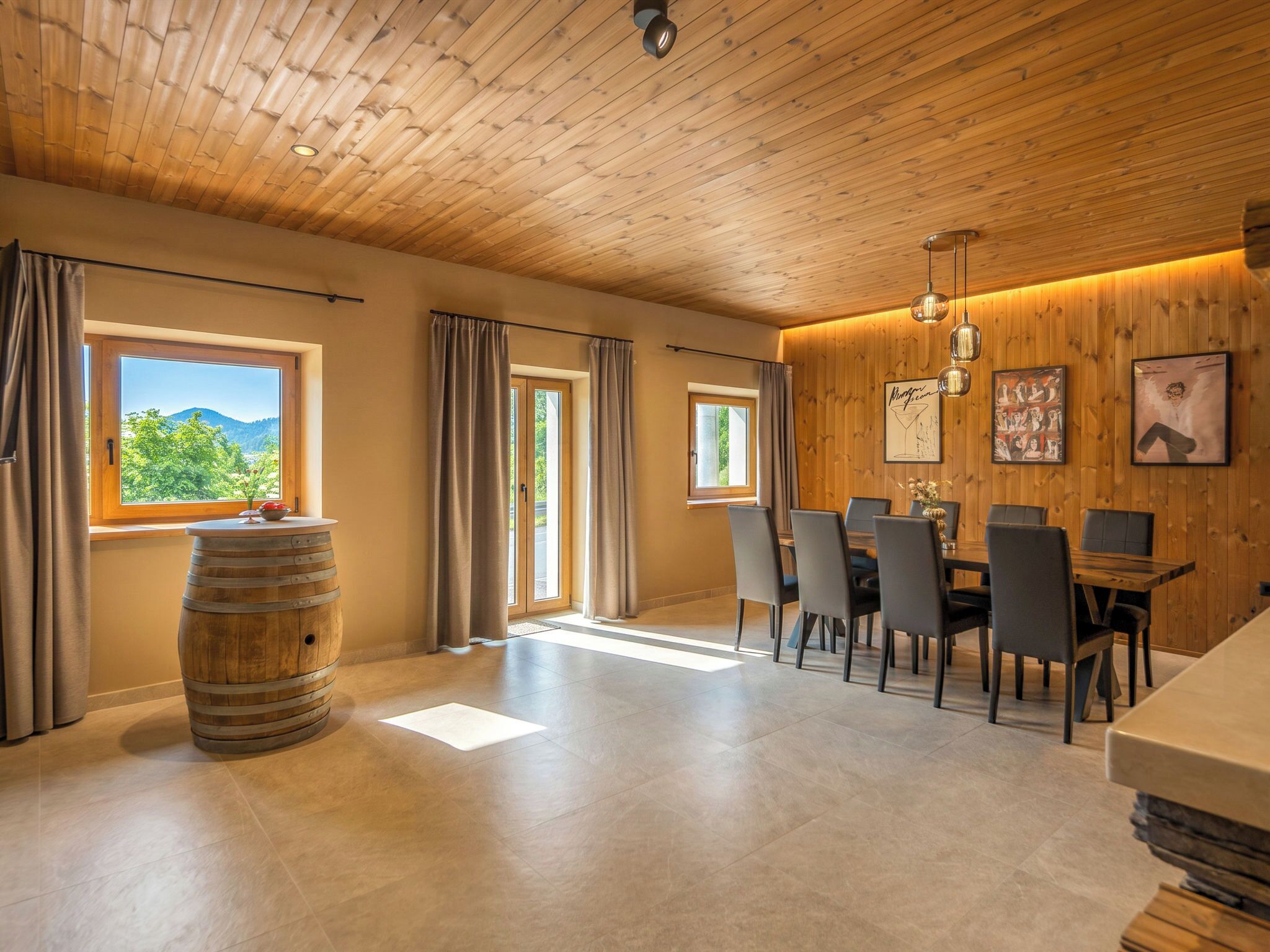 A dining area with wooden walls, a wooden ceiling, and a view of the outdoors.