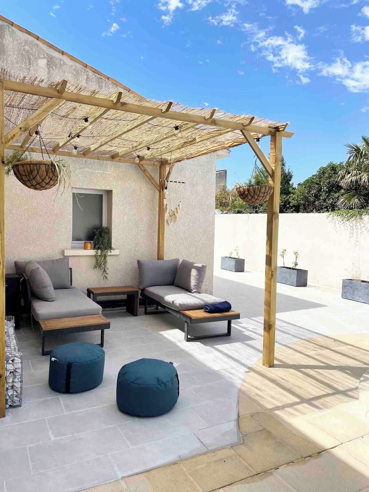 An outdoor seating area with a pergola, cushioned seating, and planters.