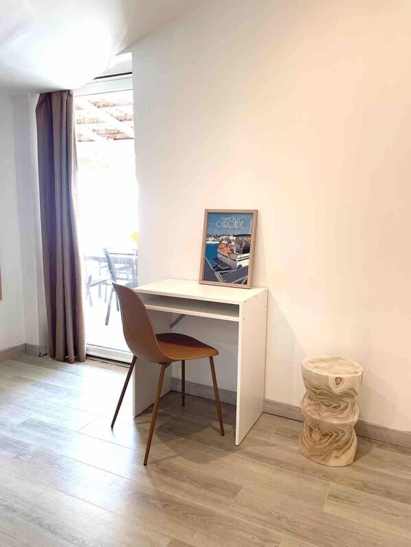 A room with a desk, chair, and a poster on the wall.