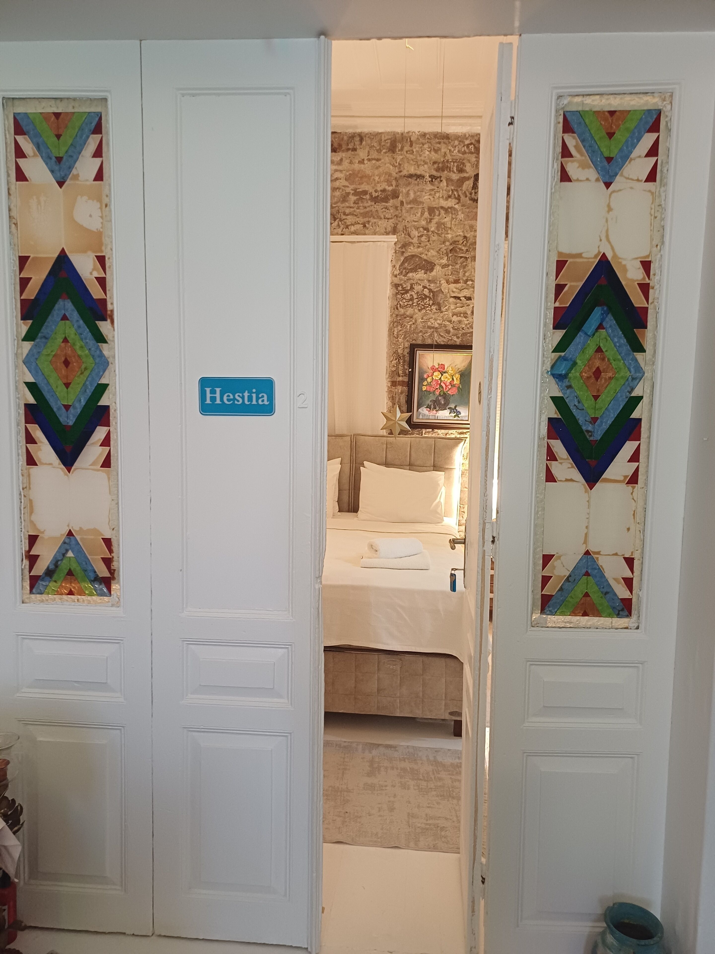 Une chambre d’hôtel avec un lit, une table de chevet et un tableau encadré au mur.