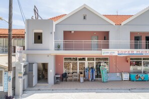 A two-story building with a storefront labeled 'SUPER MARKET' and a sign for 'Maria.' - Intimate Sea View Studio for Two in Kefalonia (Vlachata)
