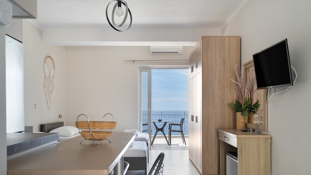 Una cucina moderna con zona pranzo, una TV a schermo piatto montata a parete e un balcone con vista.