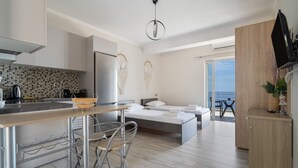 Una cucina moderna con zona pranzo, un letto con vista e un balcone.