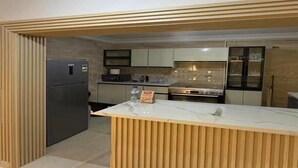 Una cocina moderna con una isla central, electrodomésticos integrados y una pared decorativa de madera.