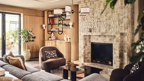 Una sala de estar moderna con chimenea, estanterías de madera y un sofá.
