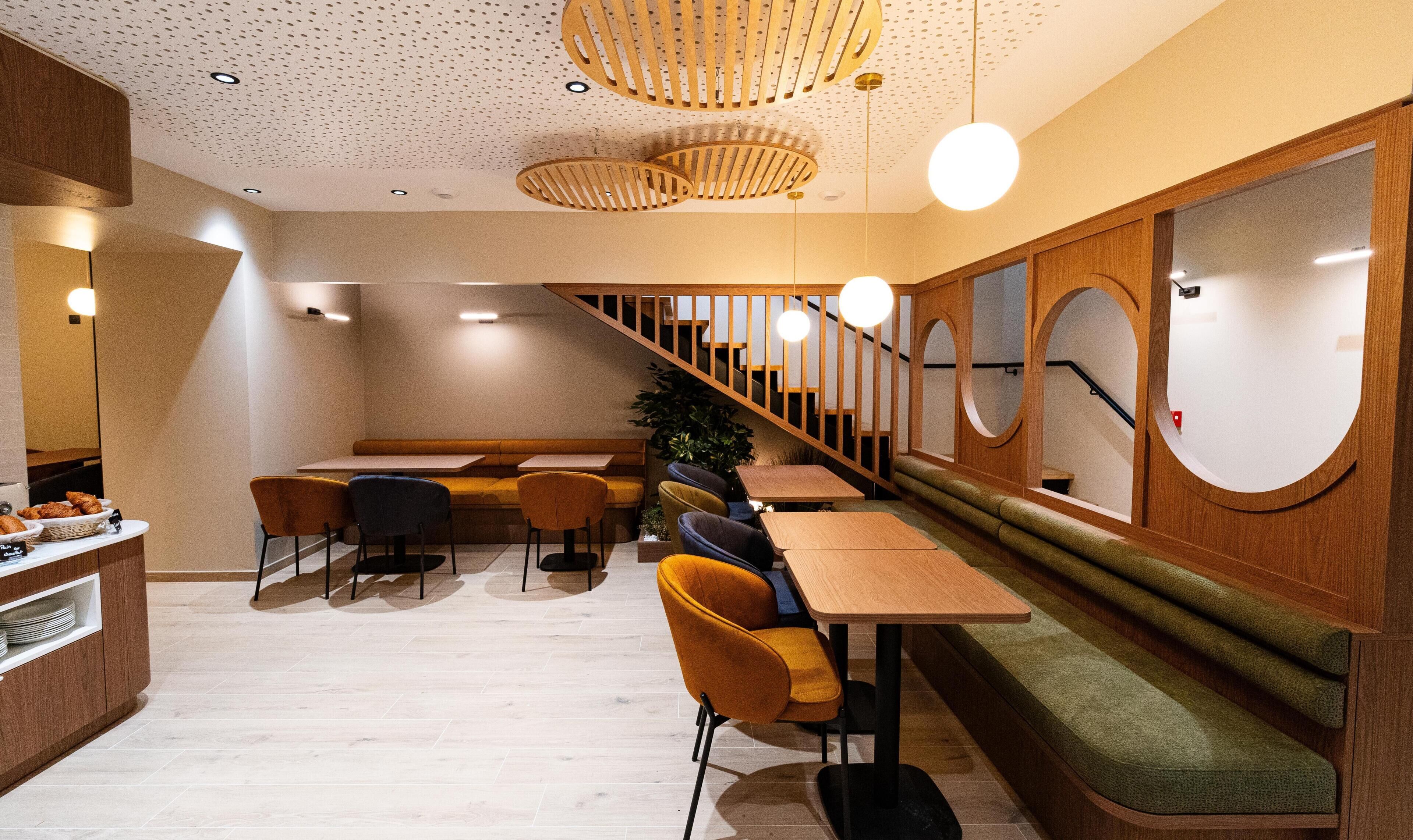 Un interior moderno con muebles de madera, una escalera y una planta.
