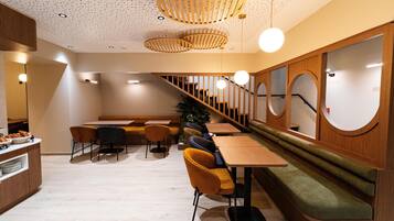 Un interior moderno con muebles de madera, una escalera y una planta.