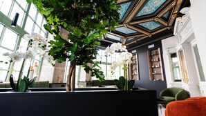 A modern interior with a large tree, bookshelves, and a geometric ceiling design. - Hotel & Spa des Beaux-Arts Bourges, a member of Radisson Individuals (Bourges)