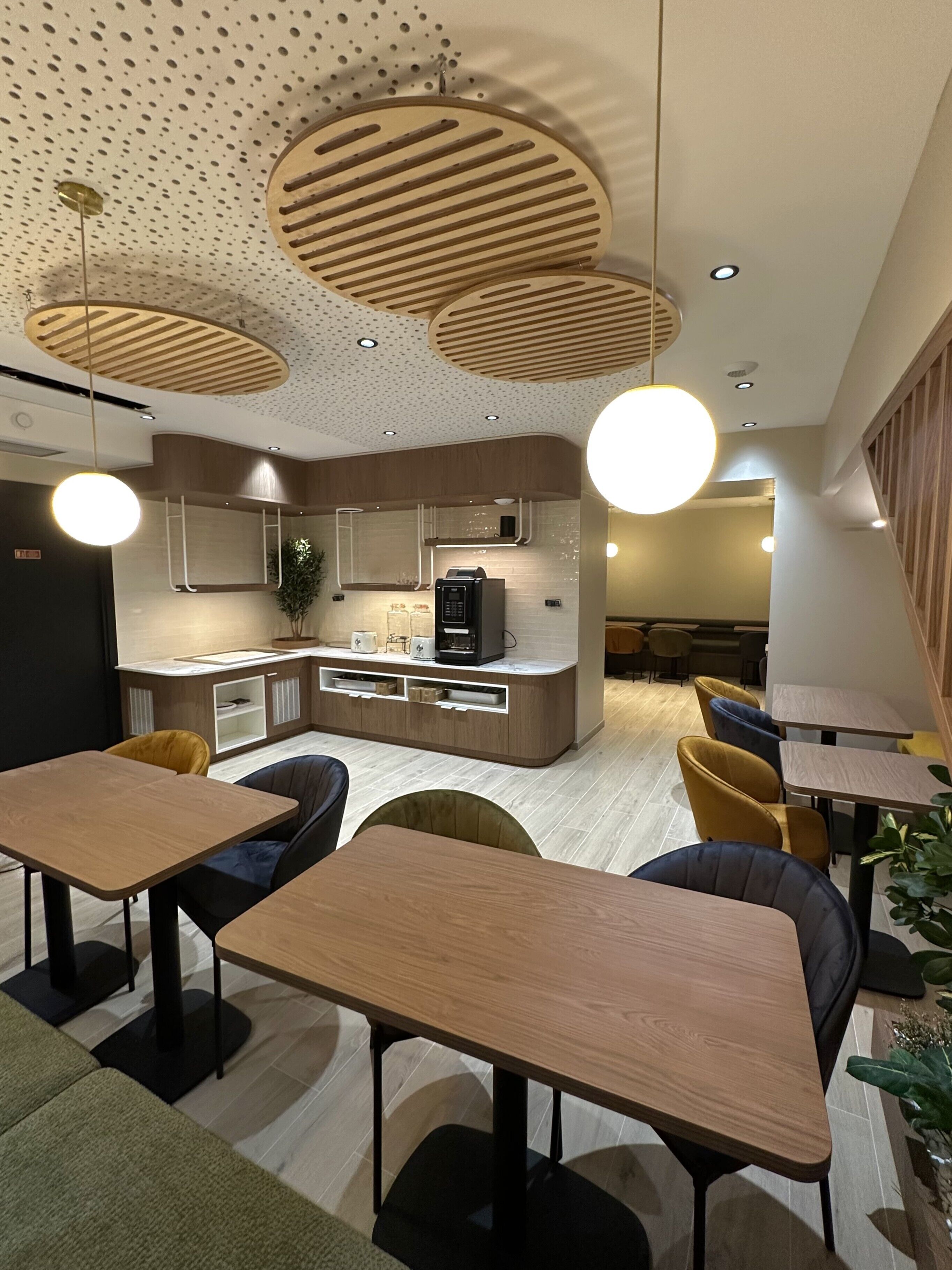 A modern interior with a kitchen area, dining tables, and chairs.