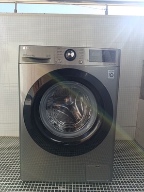 Eine LG DirectDrive Waschmaschine mit Frontlader, 9 kg Fassungsvermögen, einer Bedienkonsole, einer 10-jährigen Garantie und einem Metallrostboden.