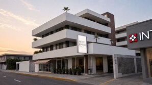 Un hotel moderno con techo plano, varios balcones y un letrero que indica que es el HOTEL Riviera.