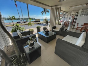 A modern lounge area with a glass coffee table, sofas, and potted plants. - Hotel Riviera Tuxpan (Tuxpan)