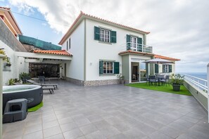 A two-story house with a balcony, outdoor seating, and a hot tub. - Villa Emilia by Atlantic Holiday (Calheta)