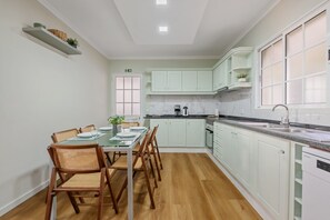 A kitchen with a dining table, chairs, cabinets, and a dishwasher. - Villa Emilia by Atlantic Holiday (Calheta)