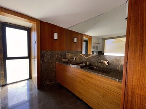 A modern bathroom with a large mirror, wooden cabinetry, and a marble countertop. - Carthage Villa | 3BR Luxury · Pool · Garden (Carthage)