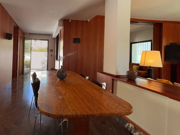 A spacious room with a long wooden table, chairs, a lamp, and a television. - Carthage Villa | 3BR Luxury · Pool · Garden (Carthage)