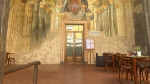 Ein Innenraum mit hoher Decke, Rundbögen und einem Wandgemälde.