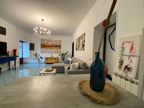 A living room with a sofa, coffee table, and decorative vase. - Garghe House apartment in the historical center Sorrento (Sorrento)