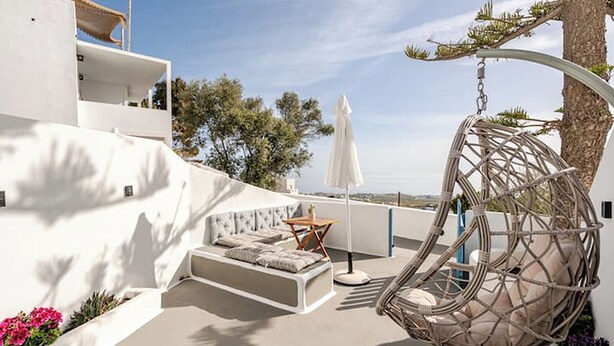 A rooftop terrace with a hanging chair, a sofa, and a table. - Simplicity Suite, Sea view, cosy place near Fira Center, high speed internet! (Fira)