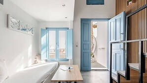 A modern room with a bed, a table, and a view of the outside. - Simplicity Suite, Sea view, cosy place near Fira Center, high speed internet! (Fira)