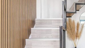 A staircase with wooden paneling on one side and a modern design on the other. - Simplicity Suite, Sea view, cosy place near Fira Center, high speed internet! (Fira)
