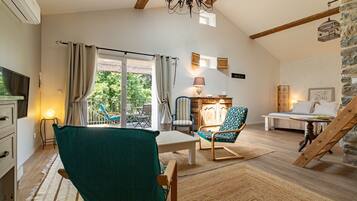 Ein gemütliches Zimmer mit Esstisch, Stühlen, einer Couch, einer Lampe und einer Treppe.