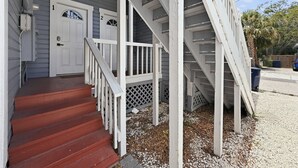 A two-story house with a porch, a set of stairs, and a driveway. - Tampa Heights 2BR Near Riverwalk (Tampa)