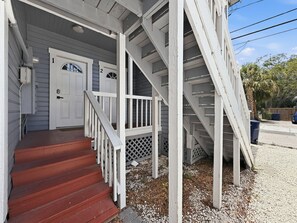 A two-story house with a porch, a set of stairs, and a driveway. - Tampa Heights 2BR Near Riverwalk (Tampa)