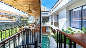 A modern building with a rooftop terrace, outdoor seating, and a small pool. - Sekala Coliving Canggu (Tibubeneng)