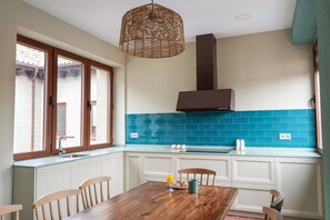 A kitchen with a window, a hanging light, and a blue backsplash. - Holiday Home 'Villa Almudena' with Private Pool, Wi-Fi and Air Conditioning (Nava de la Asunción)