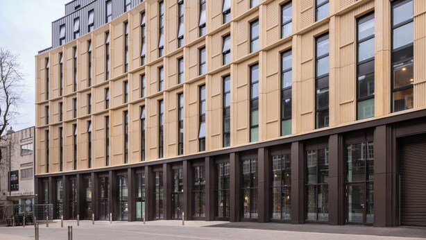 Un edificio moderno con una facciata a griglia di finestre e un tetto piatto.