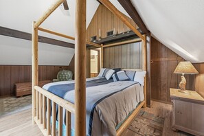 A wooden four-poster bed in a room with a sloped ceiling and wooden walls. - Mountain Cabin w/ Hot Tub - Sleeps 6 (Peshastin)