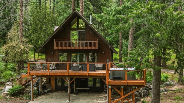 A cabin with a deck, outdoor seating, and a fireplace. - Mountain Cabin w/ Hot Tub - Sleeps 6 (Peshastin)