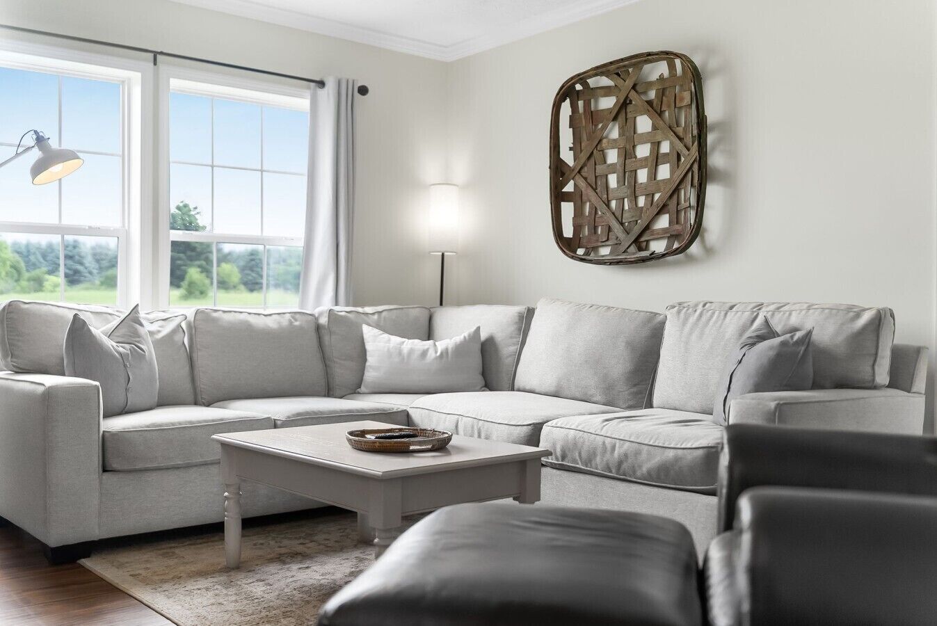 A modern living room with a sectional sofa, a coffee table, and a wall-mounted decorative piece.
