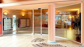 A spacious lobby with a tiled floor, a central column, and a glass partition. - Seafront Terrace & Wi-Fi [600m from station]. (Menton)