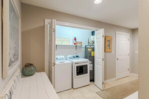 A laundry room with a washing machine, dryer, and a water heater. - Sun Realty pet-friendly oceanside Duck home w/ pool, hot tub & sound views (Duck)