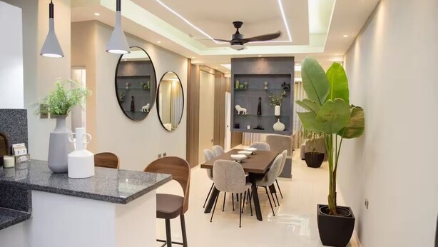 A modern kitchen with a dining area, a ceiling fan, and a large potted plant. - Marcial Luxury Apartments - Apt 2A (Baní)