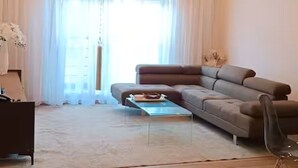 A modern living room with a sofa, a coffee table, and a hanging light fixture. - Legacy Unit - Central Yet Serene - Pool & Fast WiFi (Plum)