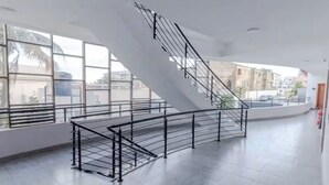 A spacious interior with a curved staircase, large windows, and a tiled floor. - Legacy Unit - Central Yet Serene - Pool & Fast WiFi (Plum)