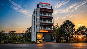 A multi-story hotel with a prominent sign, balconies, and a garage entrance. - Hotel Bhawani (Udaipur)