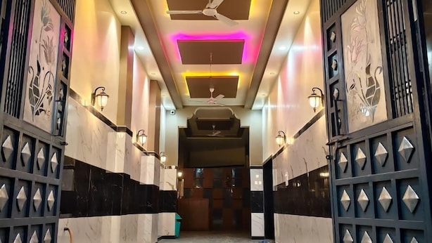A hallway with a ceiling fan, recessed lighting, and decorative panels. - Hotel Bhawani (Udaipur)