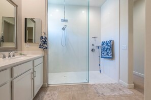 A modern bathroom with a glass-enclosed shower, a vanity with a mirror, and a towel rack. - Sleek Mid-Century Style Home in Rancho Mirage (Rancho Mirage)