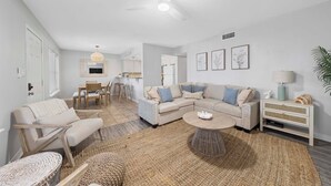 Un salon moderne avec un canapé, une table basse et un coin repas.