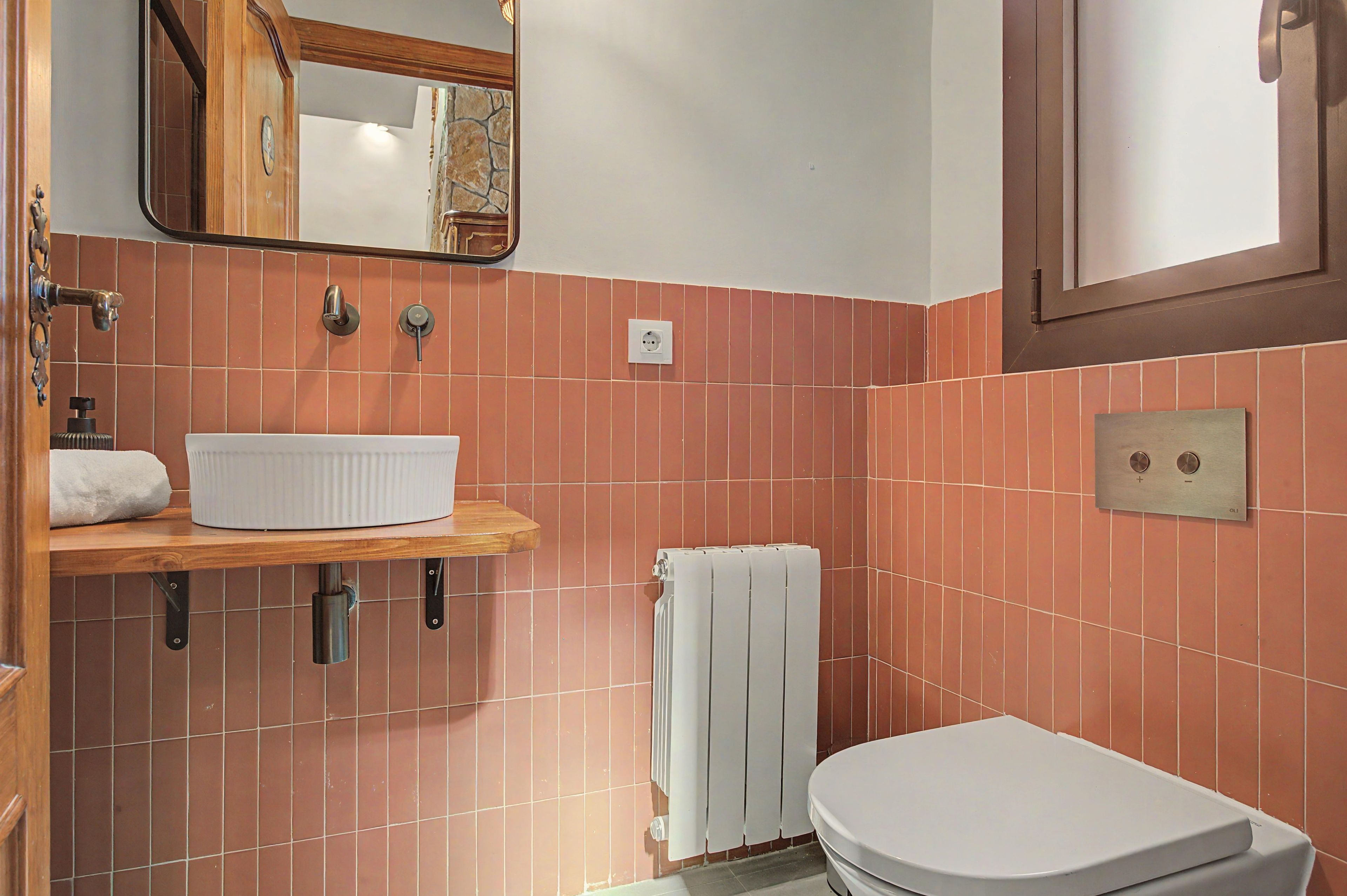 A bathroom with a white sink, a towel rack, a toilet, and a mirror.