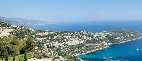 A coastal town with buildings, a beach, and a clear view of the sea.