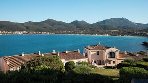 A coastal property with a large house, a view of the sea, and mountains in the background. - Casa Matilde con Patio by Wonderful Italy (Olbia)