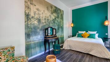 Une pièce comprenant un lit, une table de chevet, une chaise, un mur orné d’un tableau et une lampe.