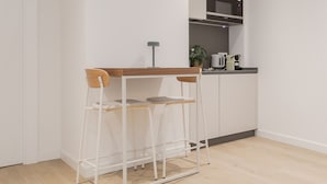A corner kitchenette with a white countertop, a microwave, a kettle, and a small potted plant. - Txapitela Rooms - Perfect for 3 (Pamplona)