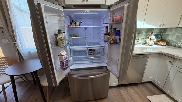 A compact kitchen with a built-in refrigerator, a dining table, and a small seating area.